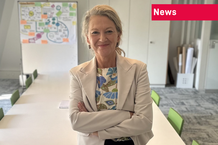 Renate Gurtner Vontobel in Business-Kleidung mit weissem Blazer und gemusterter Bluse, im Hintergrund das Sitzungszimmer des Vereins mit langem Besprechungstisch, Stühlen und Flipchart